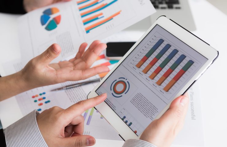 Close-up of  business team using digital tablet with financial d